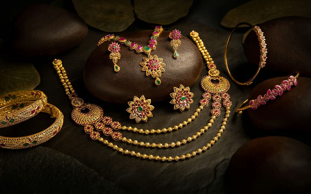 Collares, pendientes y pulseras de oro sobre piedras oscuras