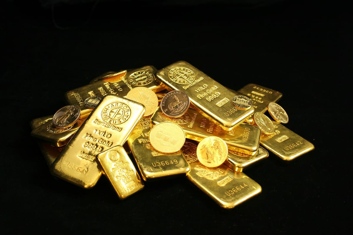 Lingotes y monedas de oro junto a una balanza digital