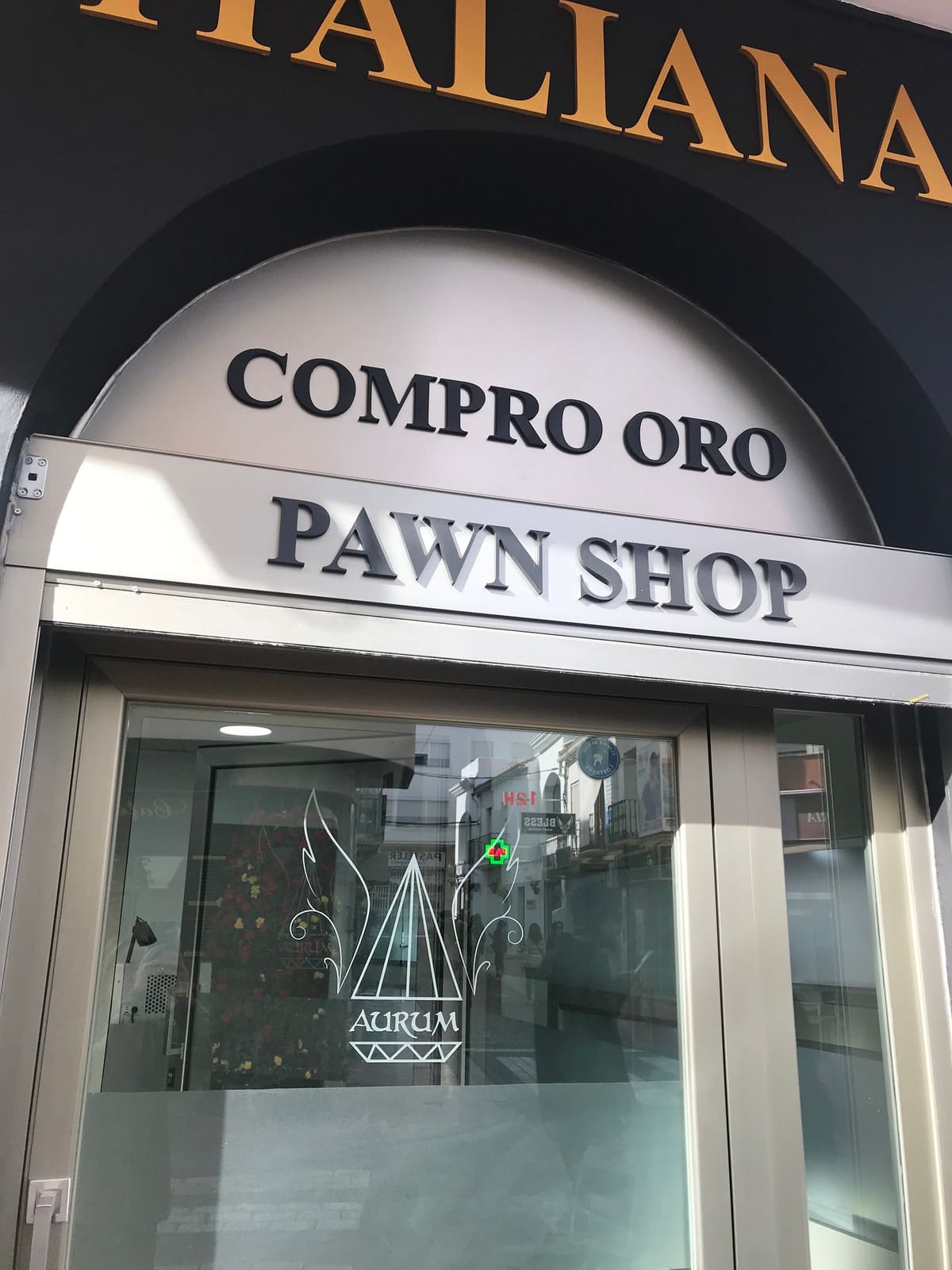 Entrada de Aurum en Estepona con los rótulos Compro oro y Pawn shop